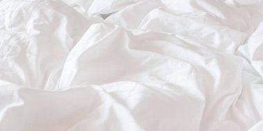 Beyaz çarşaf, buruşuk yorgan, otel, dinlenme tesisi veya iç mekanlarda yatak örtüsü ve uyku konforu için kullanılan buruşuk yorgan.