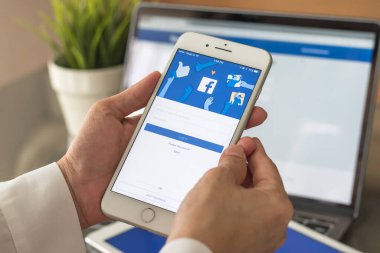 BANGKOK, THAILAND - 6 Temmuz 2017: Facebook sosyal medya uygulaması logosu giriş, mobil uygulama ekranı kayıt sayfası iPhone akıllı cihazları iş adamının elinde