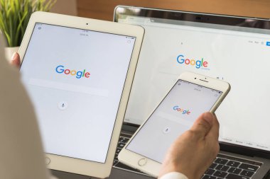 BANGKOK, THAILAND. 6 Temmuz 2017: Google arama motoru giriş sayfası mobil uygulama dokunmatik ekranı ipad, iphone iş adamının elinde ve bilgisayar ekranında