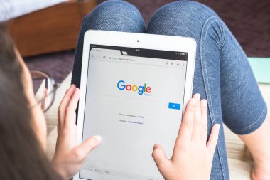 BANGKOK, THAILAND - 10 Nisan 2017: Chrome web tarayıcı ipad akıllı cihaz dokunmatik ekranındaki Google arama motoru simgeleri boş zamanlarında okul araştırmaları ve çalışmalar için kız öğrencilerin ellerinde