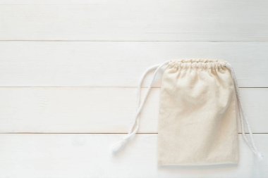 Asma ipli tuval, doğal pamuk kumaştan yapılmış küçük eko çuvalın maketi beyaz ahşap arka planda yatıyordu. 