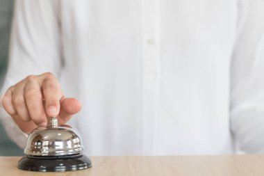 Otel restoranının çan servisi müşteri resepsiyonunda iş adamı yardım için zile basıyor. 
