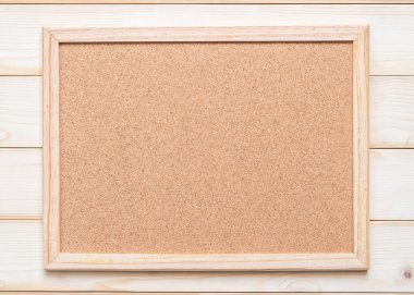 Beyaz ahşap duvarda asılı ahşap çerçeveli mantar kaplama tahtası, ilan panosu duyurusu