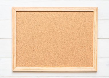 Beyaz ahşap duvarda asılı ahşap çerçeveli mantar kaplama tahtası, ilan panosu duyurusu