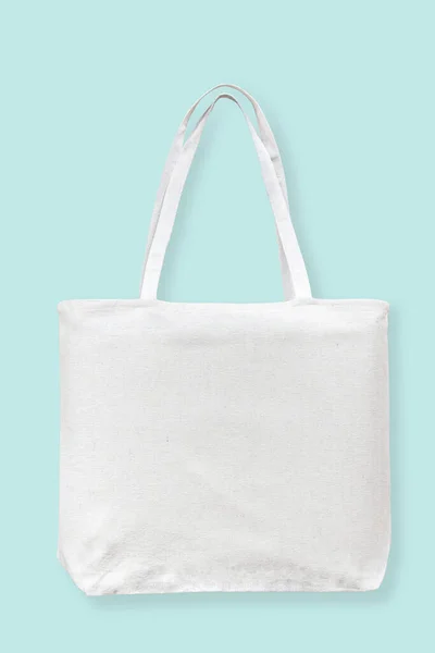 Tote bag canvas white cotton fabric cloth for eco shoulder shopping sack mockup blank template isolated on pastel blue background (clipping path)