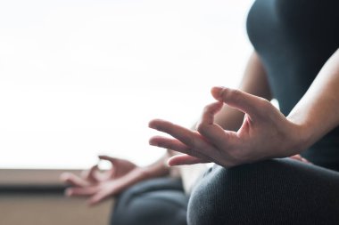 Yoga nilüferinde dinlenen kadın, sessiz beden dersinde ya da evde meditasyon yaparken poz veriyor. 