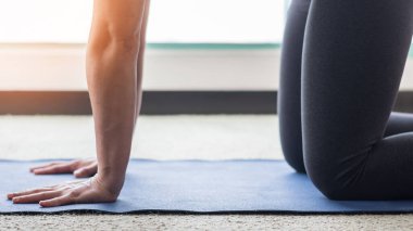 Sağlıklı yaşam tarzı için evde çalışan ve formda kalmaya devam eden sağlıklı bir kadınla pilates ya da yoga dersleri.