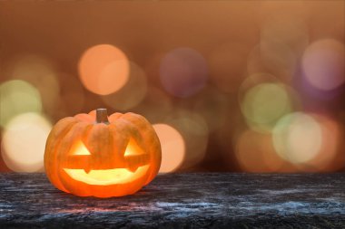 Cadılar Bayramı balkabağı Jack O 'Lantern mutlu gülümseyen surat grunge ahşap mum ışığı Cadılar Bayramı partisi için turuncu sonbahar bokeh aydınlattı.