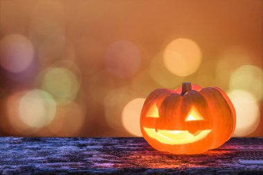 Cadılar Bayramı balkabağı portakalı Jack O 'Lantern gülen surat grunge ahşap mum ışığında Cadılar Bayramı için Cadılar Bayramı partisi için bokeh yakıyor.