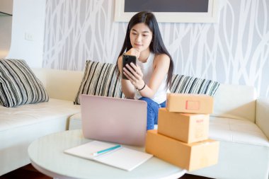 Sipariş ürünü online kontrol smartphone kullanarak Asyalı Genç kadın. Alışveriş online kavramı. 