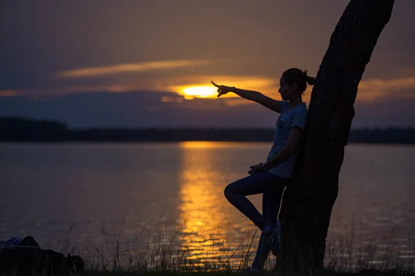 Allein Stehendes Mädchen Mit Handzeiger Auf Silhouette Sonnenuntergang Flussufer — Stockfoto