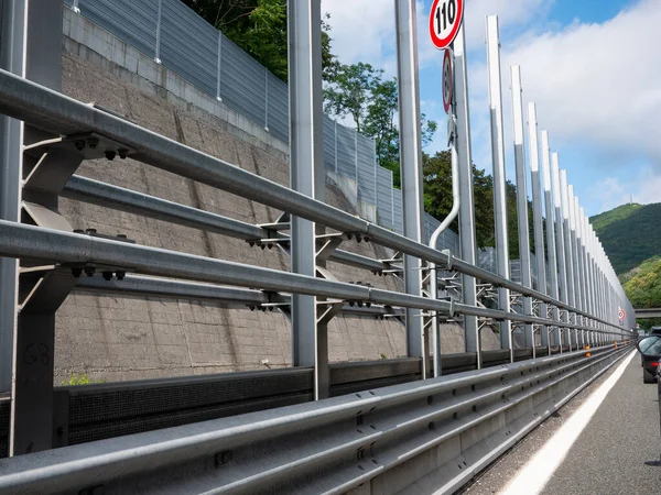 Guard rail and series of metal poles used to support the sound absorbing  barriers needed to isolate highway noise
