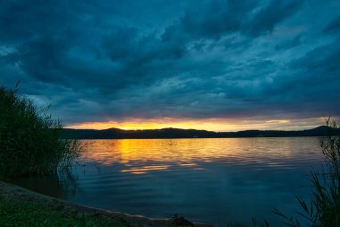 Haziran 'da bulutlu bir gölde gün batımı