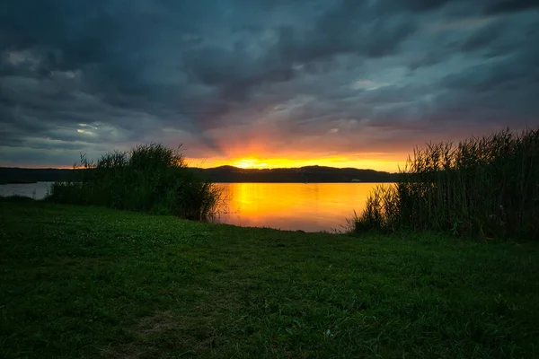 Sunset on a lake in June with clouds — Stock Photo, Image