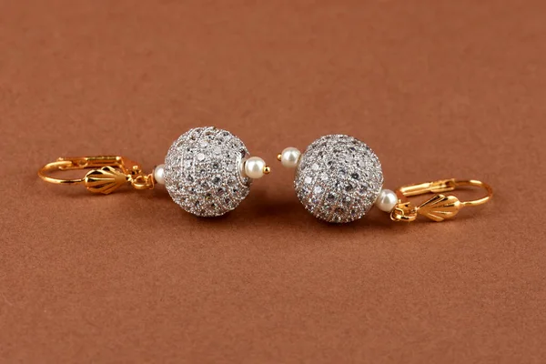 Beautiful Golden pair of earrings,diamond earrings on brrwon background. Luxury female jewelry, Indian traditional jewellery, kundan earring,Bridal Gold earrings wedding jewellery