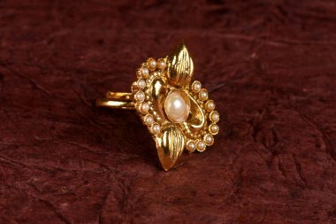 Kumaşlı arka planda görkemli antika altın yüzük. Lüks kadın mücevherleri, Hint geleneksel mücevherleri, Altın Gelinlik yüzüğü, Vintage Yüzük