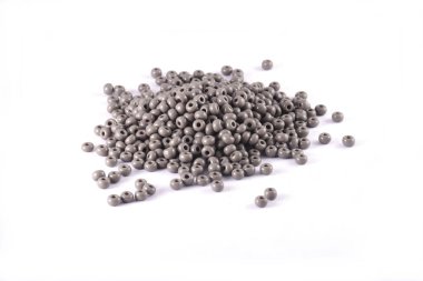 Boncuklar beyaz arka plana yayılmış. Arkaplan ya da boncuk dokusu. Yaklaş makro, moda kıyafetlerini bitirmek için kullanılır. Boncuklu kolye ya da boncuklu boncuk yap moda kadını, Boncuk Tığ. Günlük Boncuk.