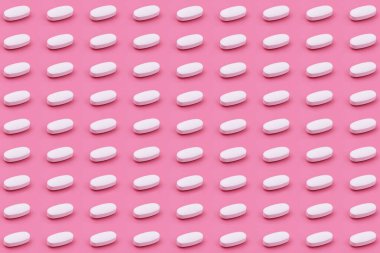 Pembe arka planda beyaz ilaç tableti, tıp yaratıcı kavramları. Renkli kağıdın arka planına sahip minimal biçim. Moda renkler, moda desen