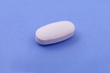 Mavi arka planda beyaz ilaç tableti, Top view. Düz yatıyordu. Uzayı kopyala Tıp kavramları. Minimalist soyut kavram. Açık mavi arkaplan