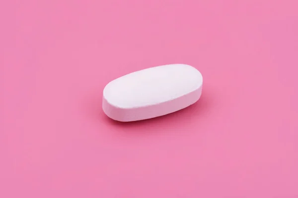 ピンクの背景に白い薬の錠剤 トップビュー 平置きだ コピースペース 医学の概念 最小限の抽象概念 ベビーピンク色の背景 — ストック写真