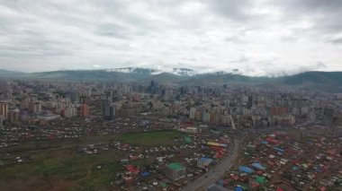 Ulaanbaatar, Moğolistan 'daki banliyölerin insansız hava aracı görüntüleri. Bulutlu şehir merkezi ve arka planda tepeler