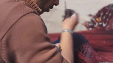 Adam balıkçı ağı yapıyor.