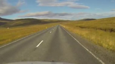 İzlanda 'da hızlı sürüş. Gün batımında yol görünümü.