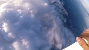 Gün batımında bulutların üzerinde paraşütle atlayan bir adamın ilk görüntüsü. Güzel manzara.