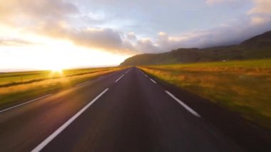 İzlanda 'da hızlı sürüş. Gün batımında yol görünümü.