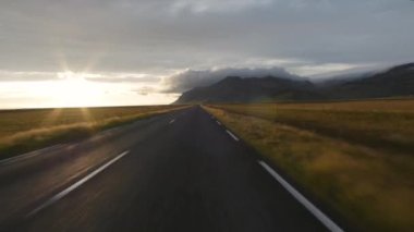 İzlanda 'da hızlı sürüş. Gün batımında yol görünümü.