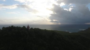 Hava aracı, Martinique 'deki ağaçların, deniz fenerinin ve okyanusun üzerinden uçtu.