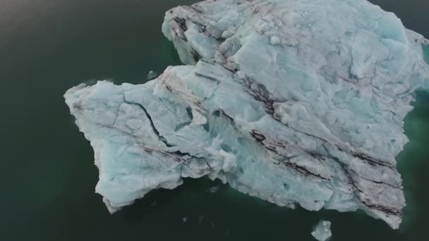 空中无人驾驶飞机在Jokulsarlon射击了一座冰山 冰岛最有名的冰川泻湖 阴天低空飞行 上楼去 — 图库视频影像