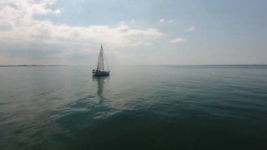 Akdeniz 'in üzerinde bir yelkenlinin etrafında uçan güzel bir dron görüntüsü..