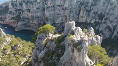 Ağaçların ve kayaların arasında uçan insansız hava aracı harika bir dereyi izleyen iki adamı keşfediyor. Fransa 'nın güneyinde Calanque d' en vau. Güneşli bir gün