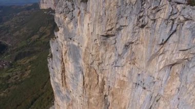 Vercors Massif 'te bir uçurum boyunca uçan hava fotoğrafı, tepede üç adam buldu. Şarabın Fransa 'sında güneşli bir gün.