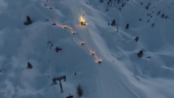 Luftaufnahme einer Pistenraupe und Motorschlitten auf einer Skipiste in den französischen Alpen — Stockvideo