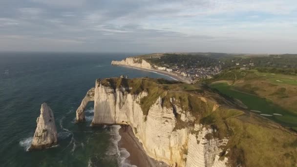 Survoler l'arc naturel d'Etretat avec la ville et la baie en arrière-plan. — Video