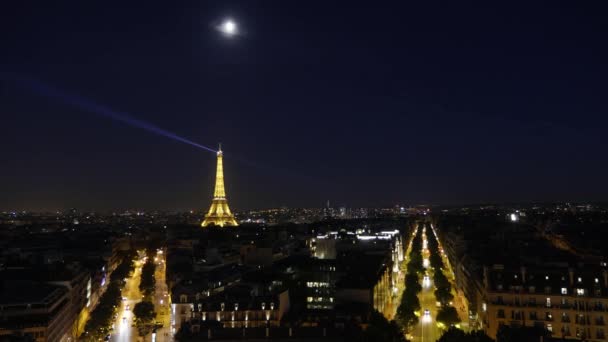 Noc se přehnala přes Eiffelovku v Paříži. Pohled z Vítězného oblouku