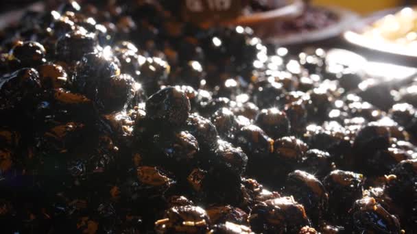 Schwarze Oliven an einem Stand Nahaufnahme Sonnenreflexion lokalen französischen Gemüsemarkt — Stockvideo