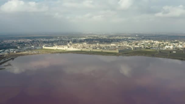 Volando hacia Aigues Mortes tarde nublada, salina rosa del estanque de sal en Camargue — Vídeos de Stock