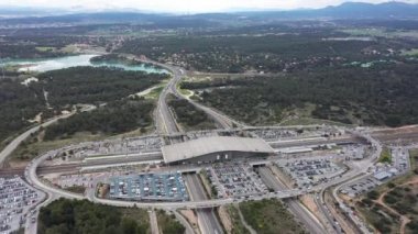 Aix-en-Provence TGV tren istasyonu hava görüntüsü arka plandaki gölde bulutlu bir gün.