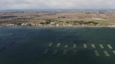 Sağdan sola, Bassin de Thau istiridye çiftlikleri üzerinde seyahat ediyorlar.
