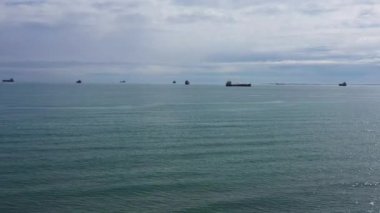 Arka planda petrol tankerleri olan Akdeniz, bulutlu bir gün, havadan çekim