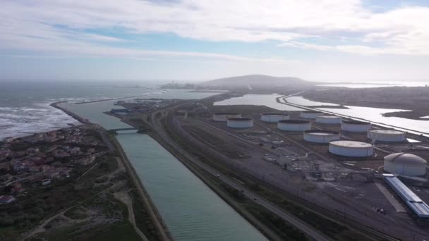 Luchtfoto terug reizend over een kustkanaal in Frontignan gaz en olieopslag. — Stockvideo