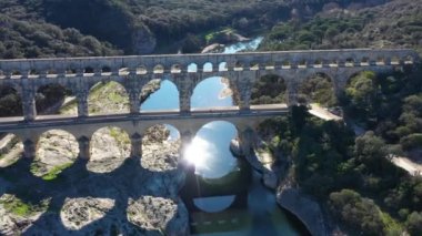 Güneşin Gardon nehri üzerindeki yansıması, Pont du Gard eski su kemeri köprüsü, Fransa 