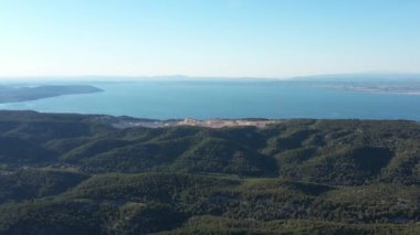 Tepedeki ormanlarda taş ocağı çıkarma ve arka plandaki Akdeniz 'de hava aracı mavi gökyüzünü vurdu.