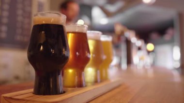 Barmen bira dökerken tezgahın üzerinde bir bardak zanaatkar bira.