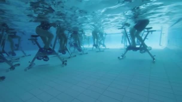 Vista subacquea di persone aqua bike in una piscina rallentatore — Video Stock