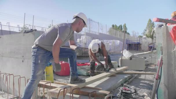 在阳光灿烂的建筑工地工作的建筑工人 — 图库视频影像