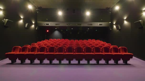 Küçük boş bir sinema salonunun küresel görünümü. Kırmızı koltuklu sinema odası — Stok video